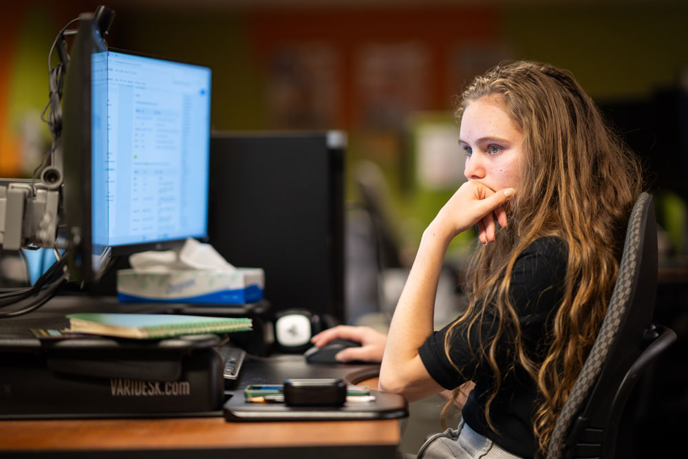 DEFENDER AT WORK — Sandia intern Grace Kenny works on a project in the Center for Cyber Defenders office. The cybersecurity internship program provides hands-on training and networking opportunities to college students. (Photo by Craig Fritz)
