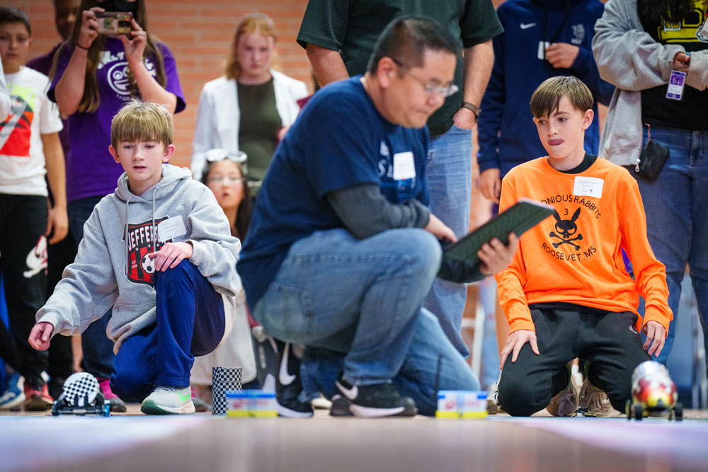 THE RACE IS ON — In the head-to-head competition, Gray Stanburry, left, from Jefferson Middle School Team 2 and Gabe Aiken from Roosevelt Middle School Team 3, race their cars in the 2023 NM Electric Car Challenge held in Albuquerque on Nov. 4, 2023. Roosevelt’s Team 3 went on to win the fastest car portion of the design challenge. (Photo by Craig Fritz)