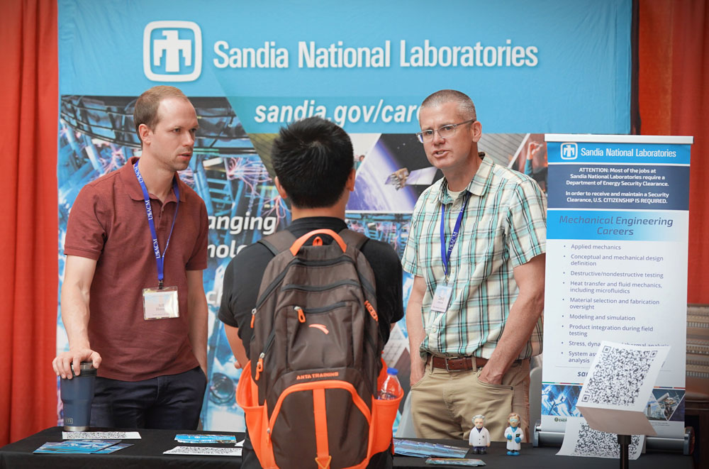 REACHING OUT — Sandia researchers Jeff Horner, left, and David Littlewood provide information to a possible Laboratories recruit. (Photo courtesy of U.S. Association of Computational Mechanics)