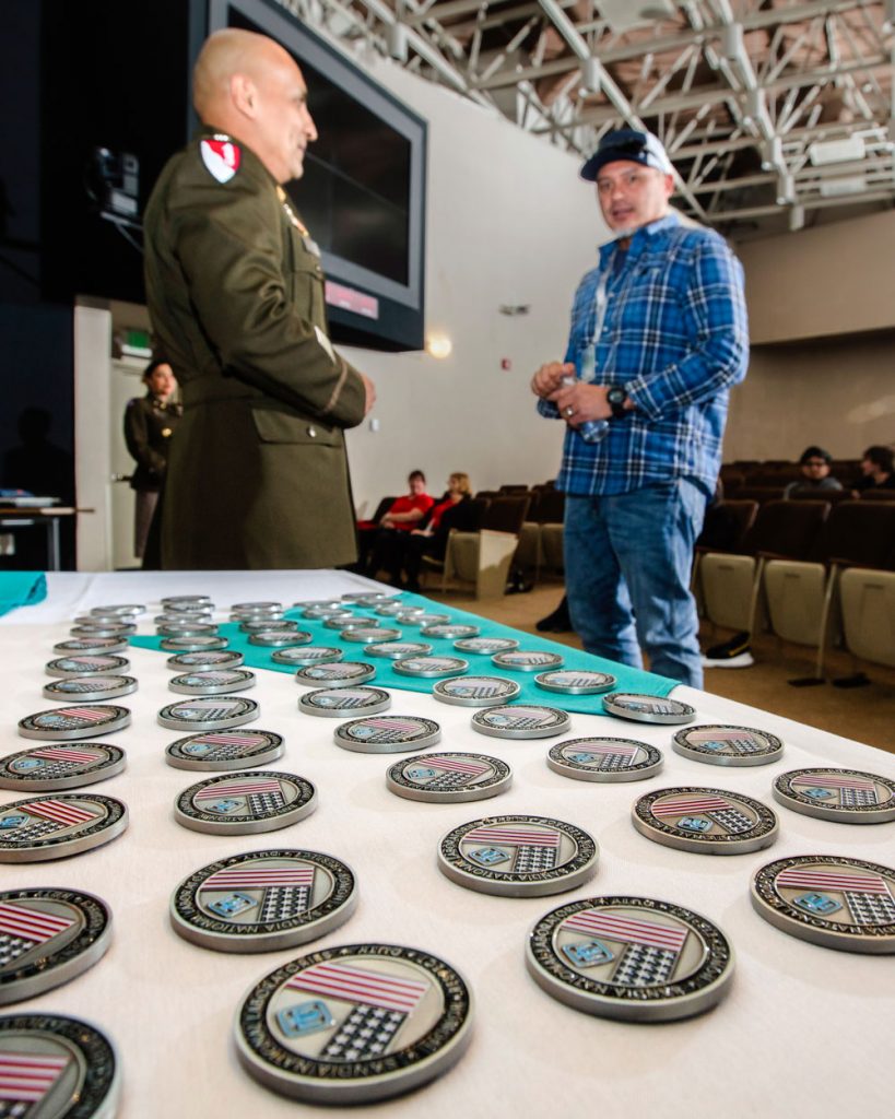 CHALLENGE COINS — Lt. Col. Ezekiel Moreno of the University of California, Berkeley, Army ROTC hands out challenge coins to veterans of the armed forces. Veterans at both ceremonies received a coin as a token of appreciation. (Photo by Randy Wong)