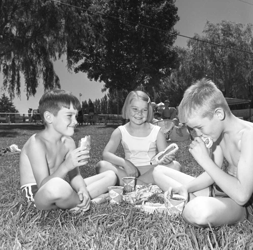 FOURTH OF JULY PICNIC — Club members and their families enjoy a day at the pool with hot dogs and soft drinks to celebrate the Fourth of July. Troy Mark Wilson is pictured here in 1968 with Maureen Neas.