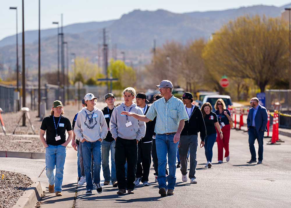 LEADING THE WAY — Sandia technologist James Scott, center, leads Rio Rancho Career and Technical Education High School welding students on a tour of the Labs. (Photo by Craig Fritz)