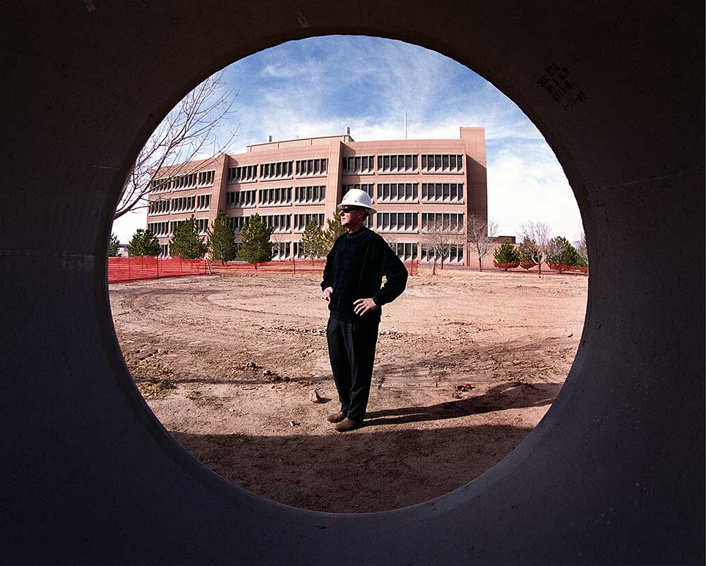 MASSIVE PROJECT — In a 2002 Lab News photo, Don Cook stands at the location where the Microsystems Engineering and Science Applications complex would be built. (Photo by Randy Montoya)