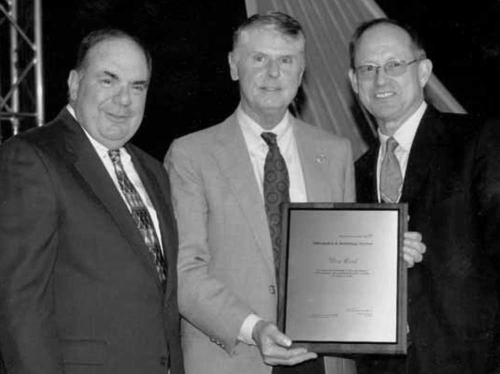 POWERFUL ACCOLADE — In a 2006 photo, Lockheed Martin Information and Technology Services Sector President Mike Camardo, left, presents Don Cook, center, with a recognition award for his work on MESA. Joining the two is then-Labs President Tom Hunter. (Photo from the Lab News archives)