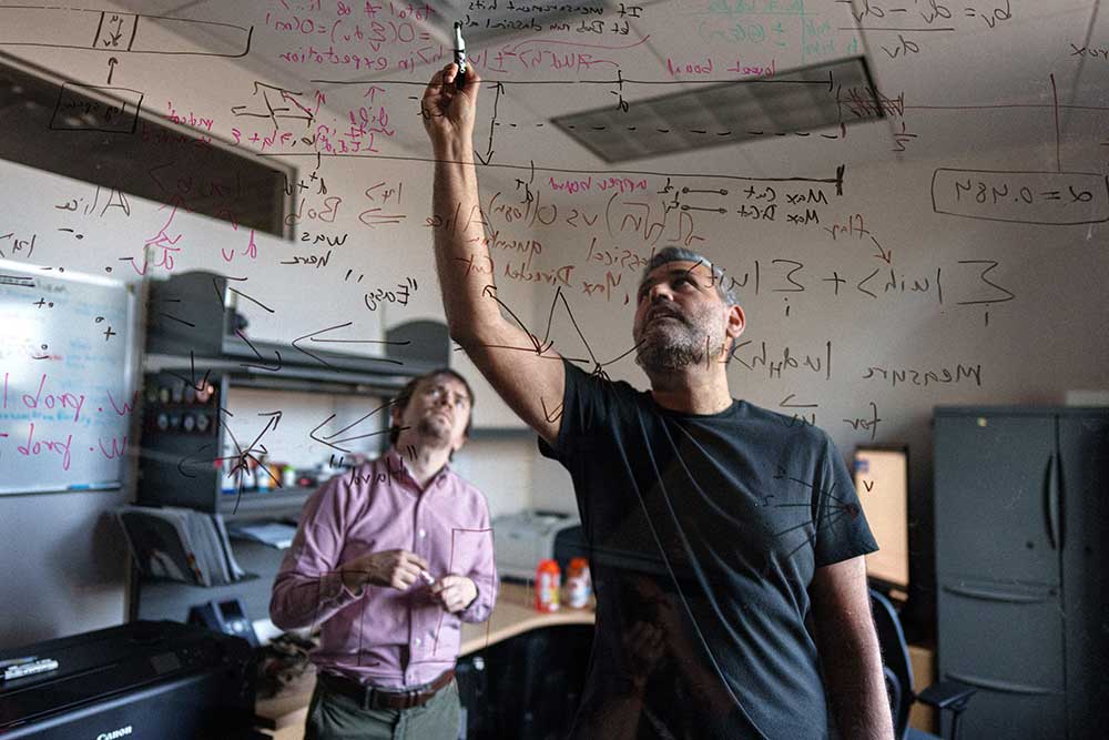 MAKING THE CUT — Theoretical scientists John Kallaugher, left, and Ojas Parekh find tasks in which quantum computers outperform normal computers, a concept called quantum advantage, at Sandia. (Photo by Craig Fritz)