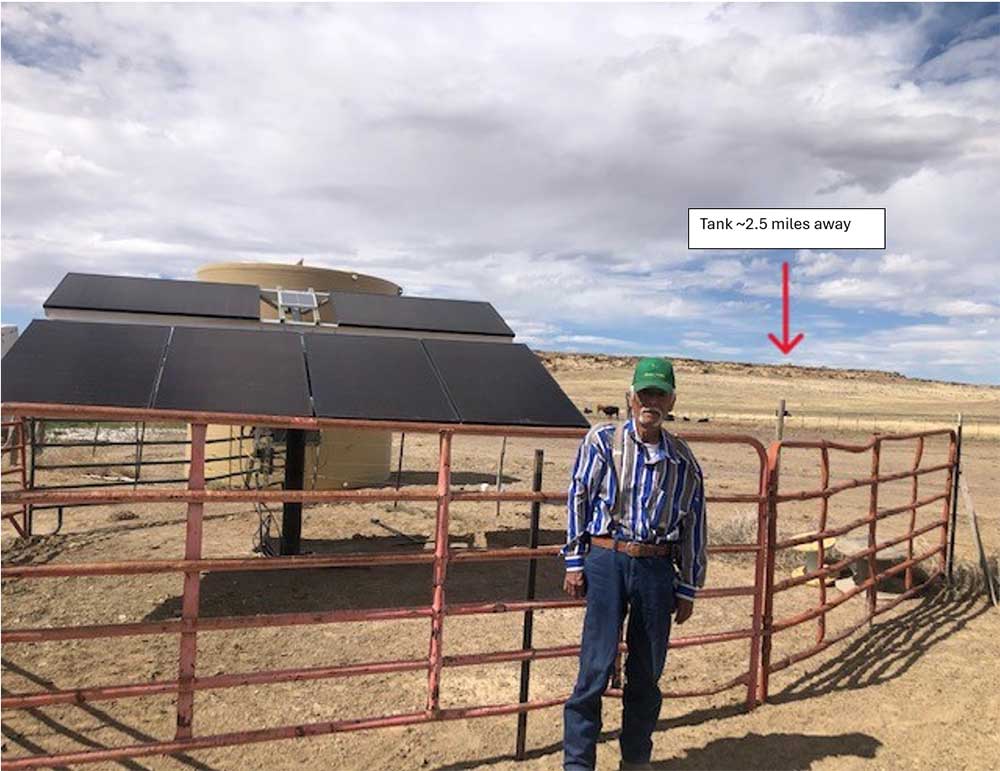A GIFT TO HIS WIFE — Johny Francis sees the success of the new watering system on his ranch before his passing earlier this year. The arrow indicates the location of the tank that gravity feeds drinkers around the ranch. (Photo courtesy of Mike Lisk)
