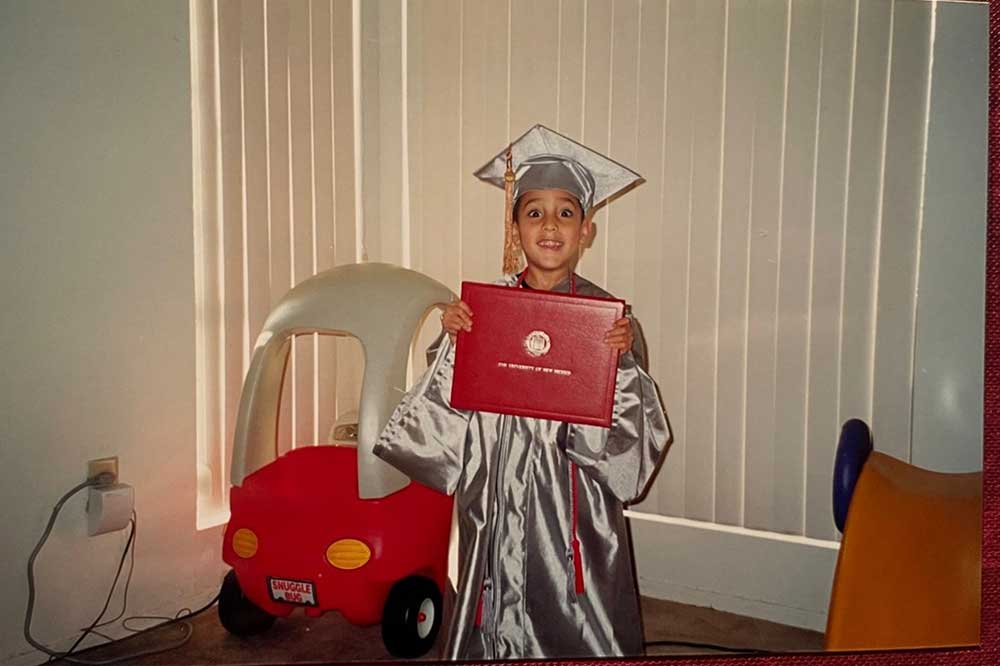 A PROUD SON — Del’s son Jesse proudly poses with his mom’s cap and gown and bachelor’s degree, earned in 2001 from the University of New Mexico. (Photo courtesy of Del Salazar)