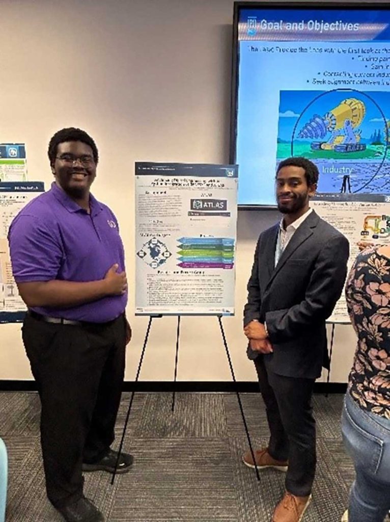 AI IN ACTION — Interns Josiah Moore, left, and Kenneth Howard present their research project ATLAS, an AI-assisted tool designed to help quality engineers with complex processes and questions. (Photo courtesy of Breanna Gallegos-Schnedar)