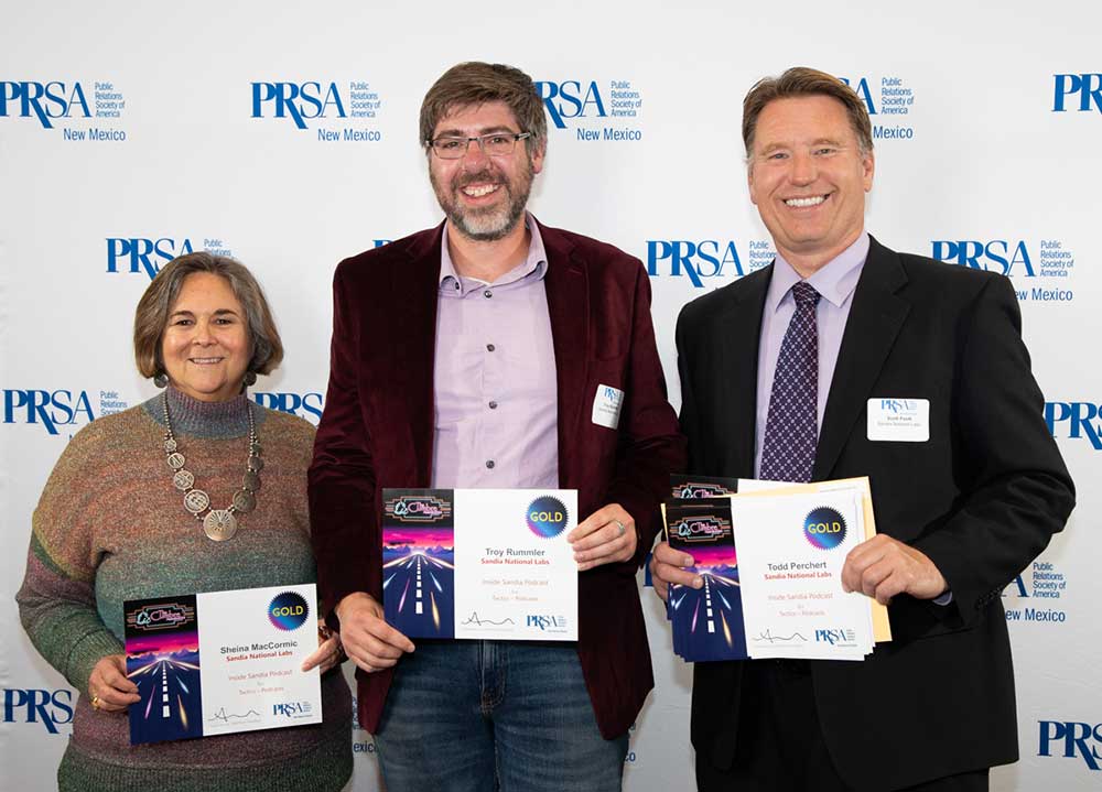 THEY’RE GOLDEN — Members of the Inside Sandia Podcast team, from left, Sheina MacCormic, Troy Rummler and Scott Faulk accept the Gold Award at the New Mexico Public Relations Society of America’s Cumbre Awards at Route 66 Hotel on Nov. 7. Scott is holding the certificate of colleague Todd Perchert. (Photo by Carey Tully, NMPRSA)