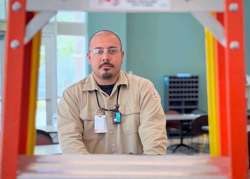 ON THE MOVE — Omar Rivera, an electrician and member of Sandia’s Lamping Crew, moves a cart into place while responding to a work order in Albuquerque. In addition to replacing burnt-out bulbs, Omar and other Lamping Crew team members inspect and maintain critical lighting systems that keep every lab, corridor and workstation safely illuminated around the clock. (Photo by James Stewart)
