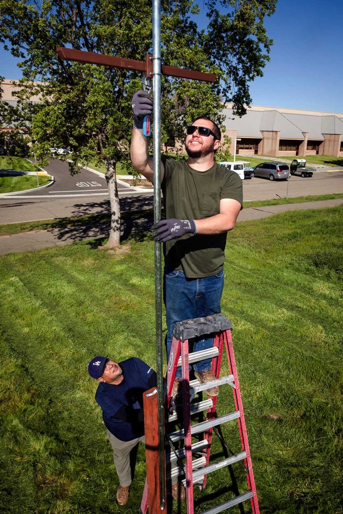 INSTALL COMPLETE — Maintenance technologists Russ Widger, on ladder, and James Diaz install a perch near the Micro and Nano Technologies Laboratory. (Photo by Randy Wong)