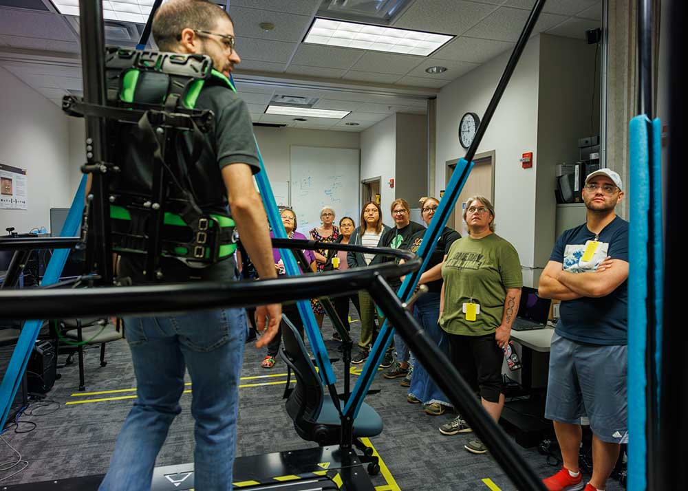 XR IN ACTION — Teachers watch a demonstration of the Infindadeck Omni-Directional treadmill which helps users realistically navigate 3D and virtual reality environments. (Photo by Bret Latter)