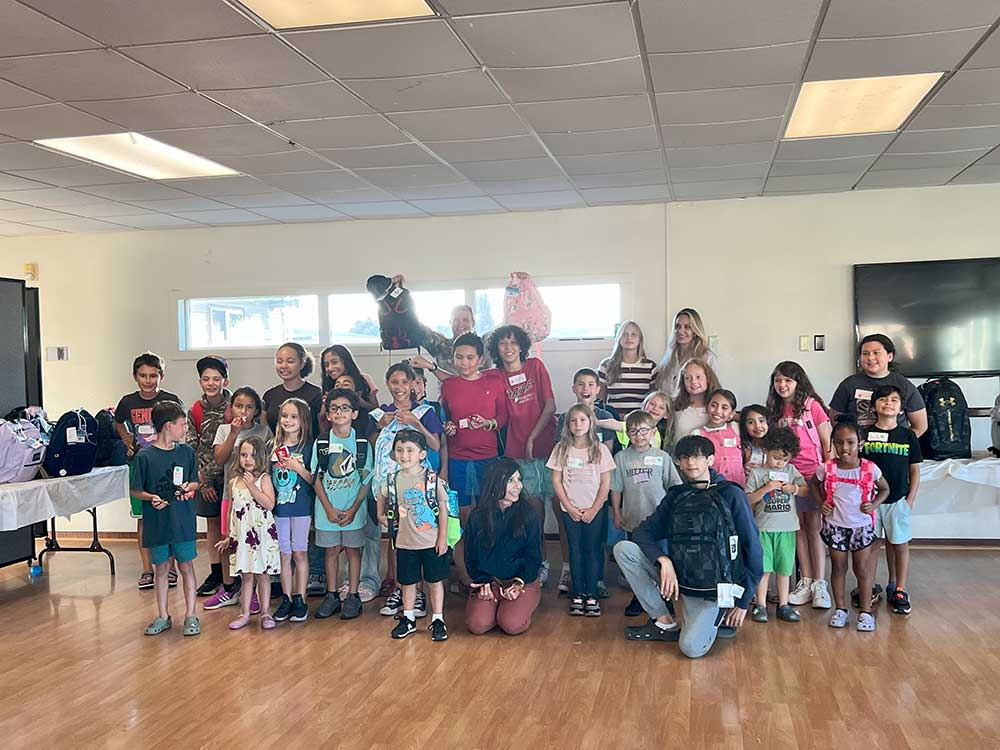 ALL SET FOR SCHOOL — A group of students at the Parks Reserve Forces Training Area try on their new backpacks filled with school supplies.