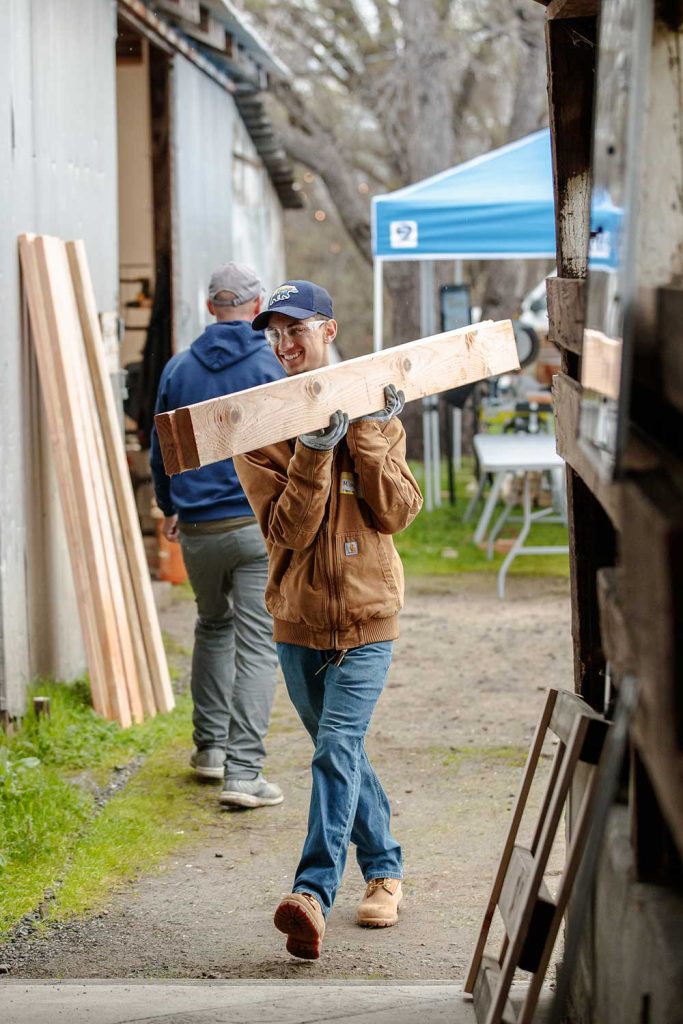 DEVELOPING DREAMS — Michael Shaik, former Community Involvement intern, carries supplies for the Sleep in Heavenly Peace bed build. Sandia partnered with a local nonprofit that supplies beds for children in need. (Photo by Spencer Toy)