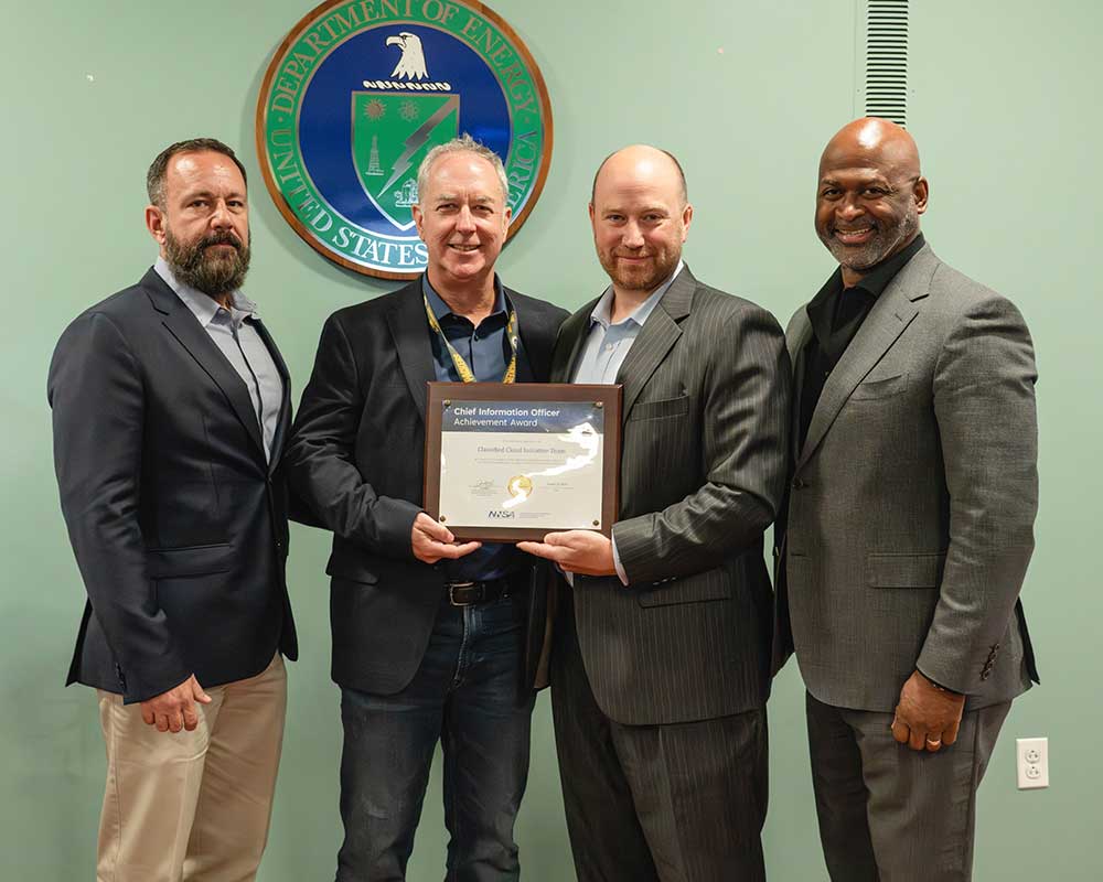 CLASSIFIED CLOUD — From left, Sandia Enterprise IT Systems Senior Manager Troy Holley and Sandia CIO Deputy Office Solutions Architect Scott Stephens accept the award from NNSA Chief Information Officer Jamie Wolff, recognizing their team’s outstanding contributions to the Classified Cloud Initiative. They are joined by William Watkins, right, director of Program Management for the NNSA Office of the Chief Information Officer. (Photo courtesy of NNSA)