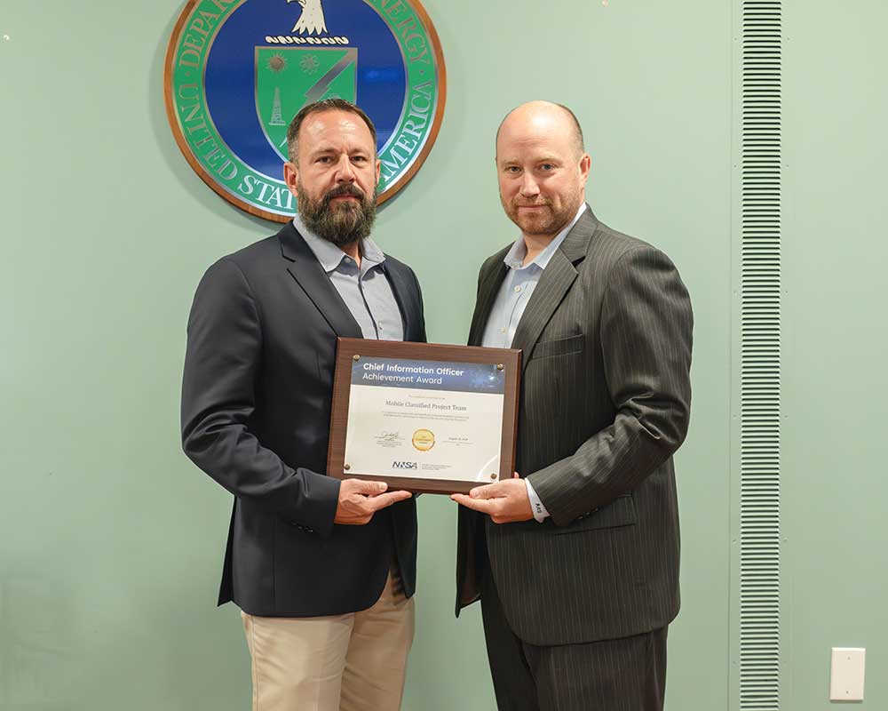 MOBILE CLASSIFIED SOLUTION — Sandia Enterprise IT Systems Senior Manager Troy Holley, left, accepts an award on behalf of the Mobile Classified Team from NNSA Chief Information Officer Jamie Wolff. (Photo courtesy of NNSA)
