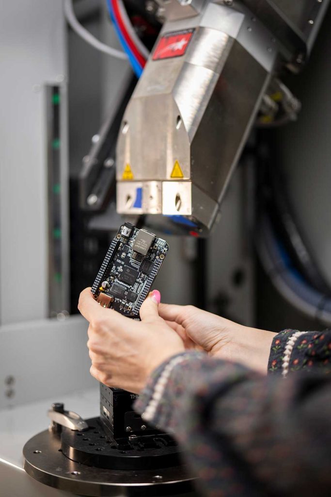 MULTI-METAL POWER — Noelle Collins sets up for an X-ray CT scan of a circuit board as part of the Non-Destructive Evaluation group at Sandia. (Photo by Craig Fritz)