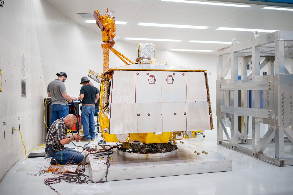 WIRING THE MISSION — Operations engineer Orlando Abeyta works on wiring prior to placing a cage around and attaching VIPER to the arm of the Superfuge at Sandia. (Photo by Craig Fritz)