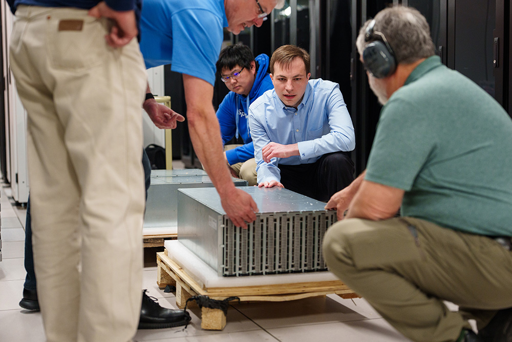NEUROMORPHIC HARDWARE&nbsp;—&nbsp;Researcher Brad Theilman unpacks a neuromorphic computing core at Sandia. While the hardware might look similar to a regular computer, the circuitry is radically different. It applies elements of neuroscience to operate more like a brain, which is extremely energy efficient.&nbsp;(Photo by Craig Fritz)