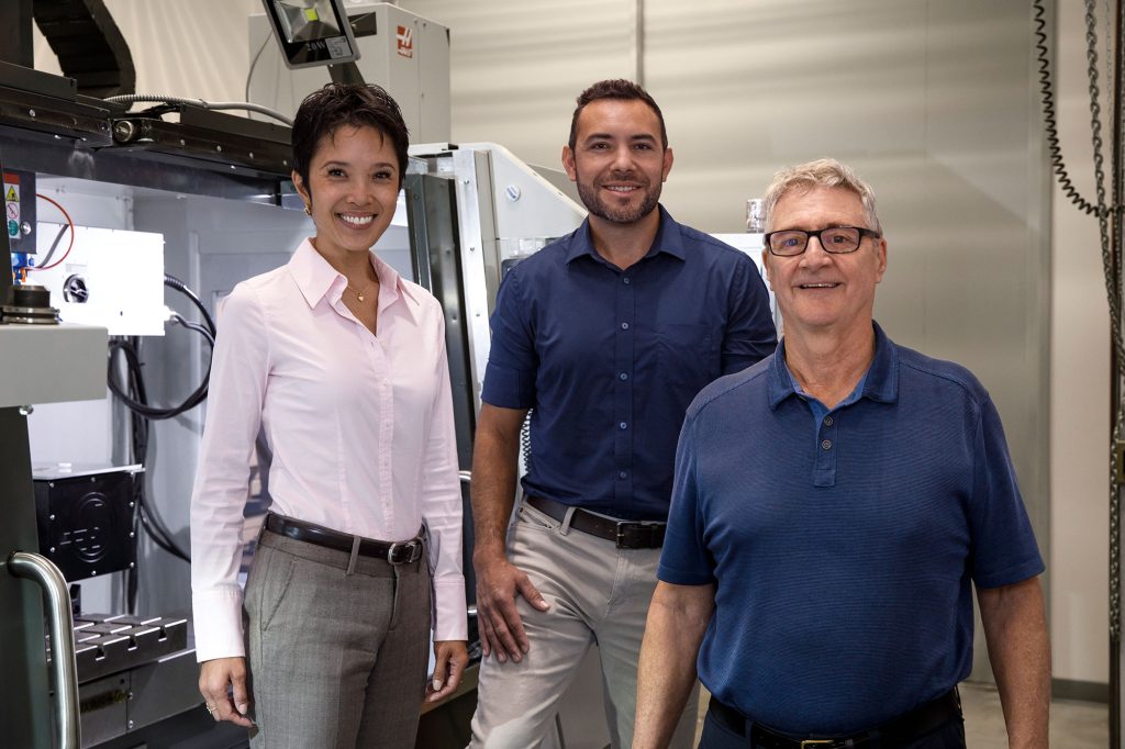 EARLY WARNING — From left, Annabelle Benin, Isaac Aviña and Patrick Doty developed and began producing the “printable” polymer-based dosimeter patches using the laser etching machine behind them. (Photo by Spencer Toy)