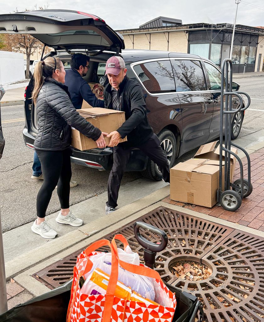 MAKING A DIFFERENCE — Managers Crystal Chavez, left, and Jeremy Pacheco unload boxes of donations at the Albuquerque Family Advocacy Center. (Photo by Amanda Armenta)