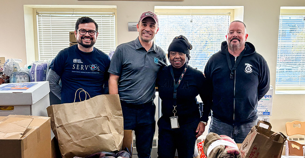 TEAM EFFORT — Managers, from left, Bernardo Diaz, Jeremy Pacheco and, right, Kent Hodges pose with the Family Advocacy Center Manager Bev McMillan. (Photo by Amanda Armenta)