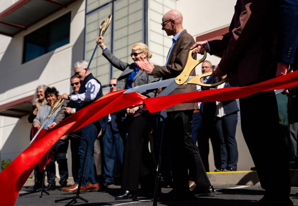 <strong>CELEBRATORY SHEARS </strong>— From left, NNSA Administrator Brandon Williams, Sandia Labs Director Laura McGill and Kansas City National Security Campus President and CEO Eric Wollerman cut the ribbon to celebrate the opening of CAMINO surrounded by their teams. (Photo by Craig Fritz)
