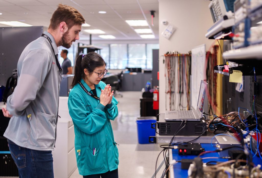 <strong>WISHFUL WAITING</strong> — Telemetry engineers Aaron Czeszynski, left, and Emily Yang anticipate success while preparing a Joint Environmental Test Unit in Telemetry and Visualization Software Realtime at Sandia California. They prepare the unit to ship to Sandia New Mexico, where it will undergo a combined environments test involving simultaneous spin and acceleration.