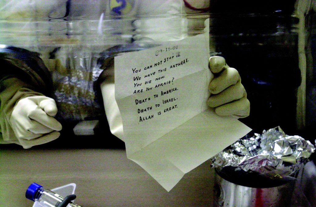 <strong>LETTERS</strong> — A laboratory technician at the U.S. Army's Fort Detrick bio-medical research laboratory holds an anthrax-laced letter addressed to Sen. Leahy in December 2001. (Photo courtesy of the FBI)