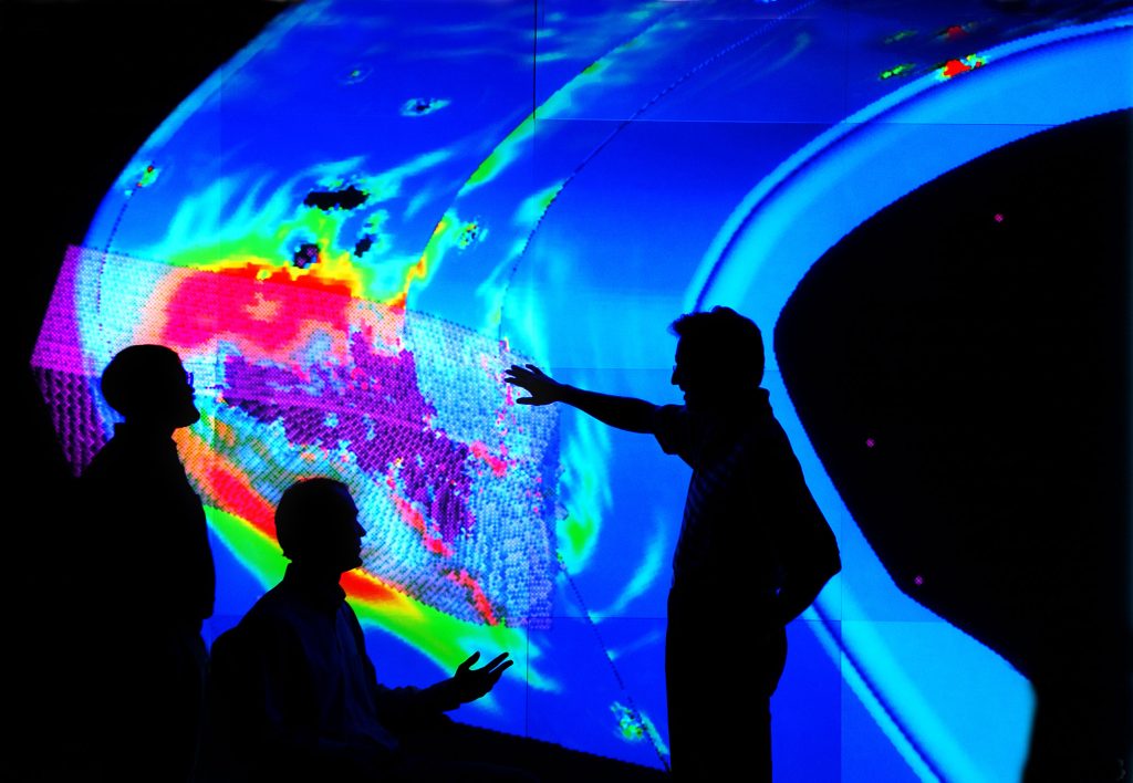 <strong>EXPLAINING THE PROCESS</strong> — In a 2003 photo, researchers review an image of a Sandia computer model and analysis of foam impacting the leading edge of the space shuttle. (Photo by Randy Montoya)