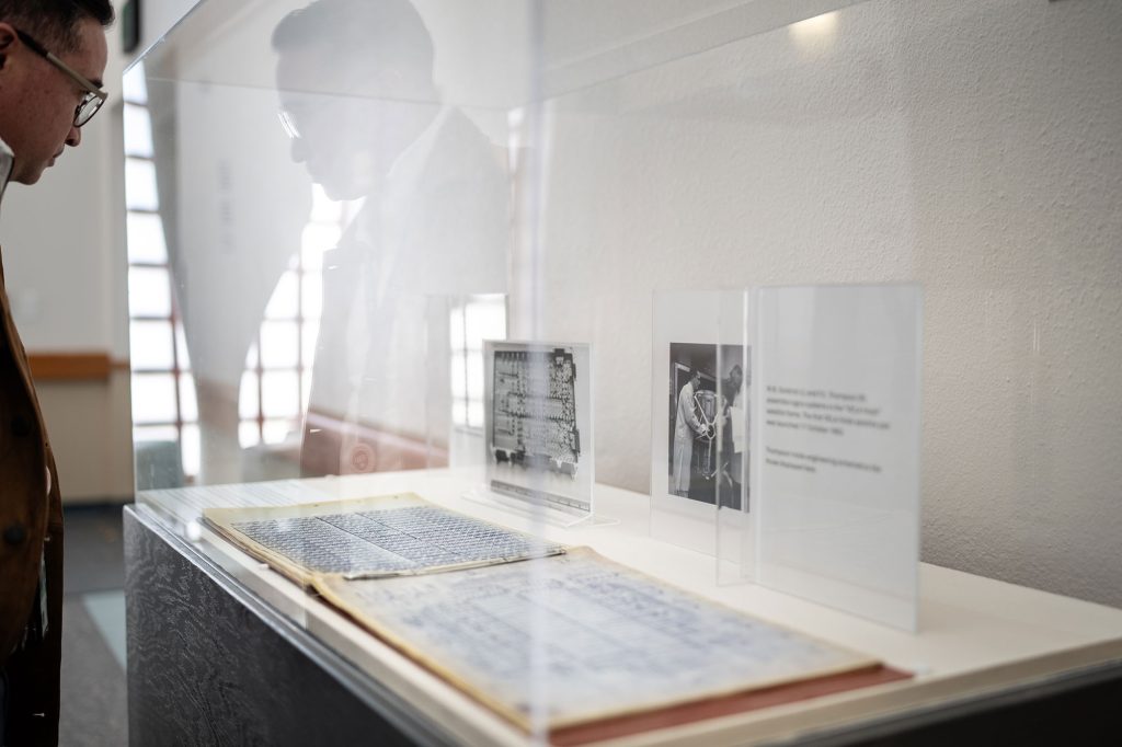 <strong>ENGINEERING OF YORE </strong>— Government Relations analyst Nick Maestas reads the unclassified <a href="https://www.sandia.gov/labnews/2026/02/20/sketchbooks-offer-view-into-sandias-early-engineering-days/">engineering design package for the Vela satellite program</a> from the late 1960s. Vela engineering artifacts were on display during a panel discussion about the evolution of engineering at Sandia. (Photo by Craig Fritz)