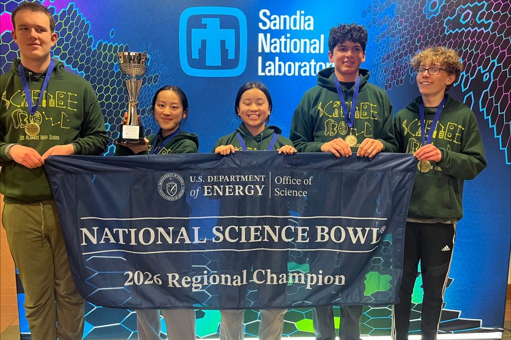 <strong>2026 DOE REGIONAL SCIENCE BOWL WINNERS</strong> —From left, Los Alamos High School Team 1 participants Henry Gans, Julia Zou, Ming-Xiu Lo, Andrew Bacrania and Gavin Bent hold the regional championship flag. (Photo by Deb Menke)