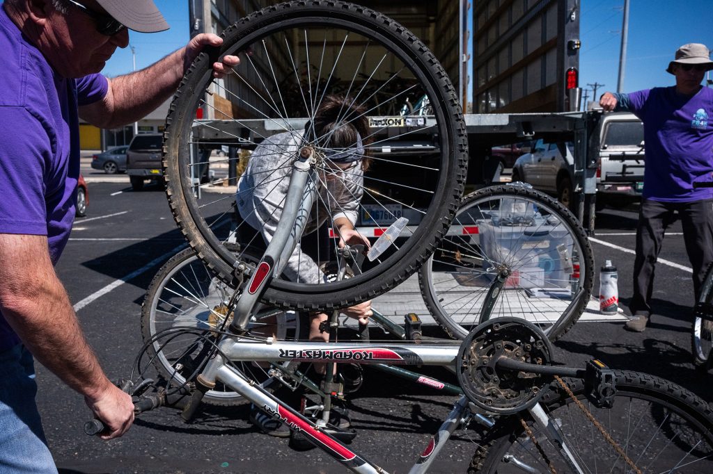 <strong>FREE BIKES </strong>— Sandia physicist Amanda Dumi, behind the spokes, repairs one of 48 bikes donated during the Free Bikes 4 Kidz-New Mexico event at the Trek Store on April 4. Free Bikes 4 Kidz-New Mexico is a nonprofit geared toward children’s health and happiness by providing bikes to families in need. The community donates gently used bikes to the organization, which mobilizes volunteers to clean and refurbish them, then gives them away through after-school programs, health clinics, church groups, crisis centers and tribal organizations. (Photo by Craig Fritz)