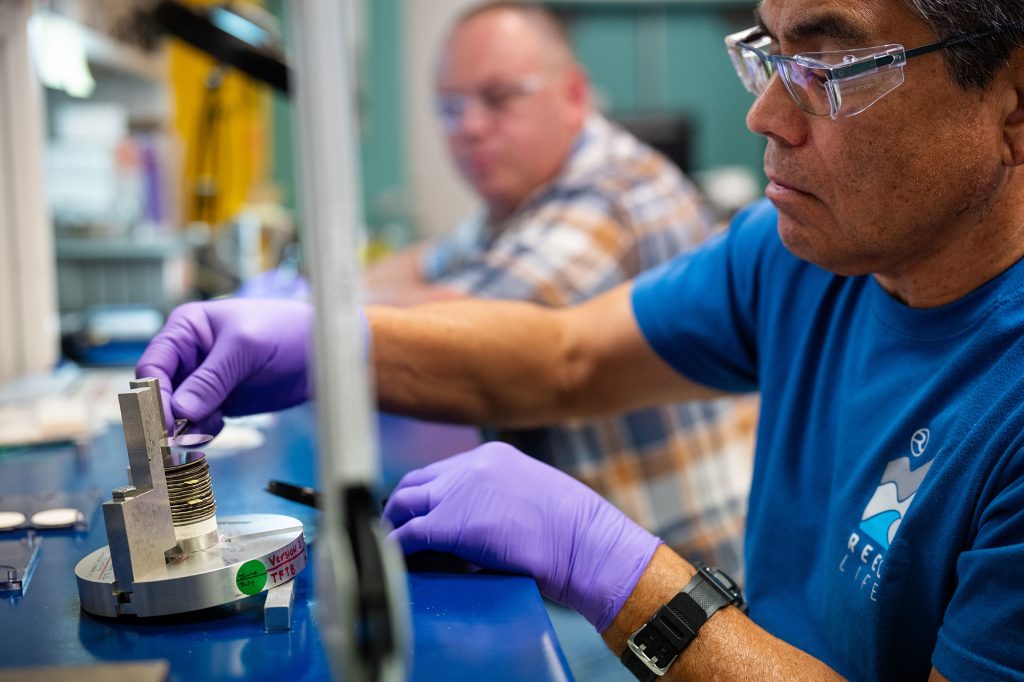 <strong>QUALITY CHECKS</strong>—A Sandia technologist works on a thin film thermal battery as his colleague performs quality assurance checks for the Power Sources Capabilities team. (Photo by Craig Fritz)