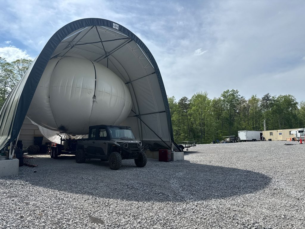 <strong>BALLOON SETUP</strong> — The typical footprint of a tethered balloon field campaign consists of the balloon and launch vehicle, a temporary hangar and three to five containers or trailers. (Photo by Antigravity Films)<br>