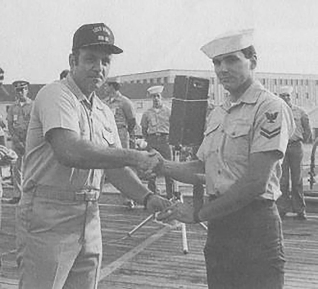 <strong>WRONGLY ACCUSED</strong> — United States Navy Capt. Fred Moosally, left, presents Gunner's Mate 2nd Class Clayton Hartwig with a duty award in Norfolk, Virginia, in 1988. Hartwig was wrongly accused for deliberately causing the USS Iowa explosion. (Photo from the U.S. Navy)