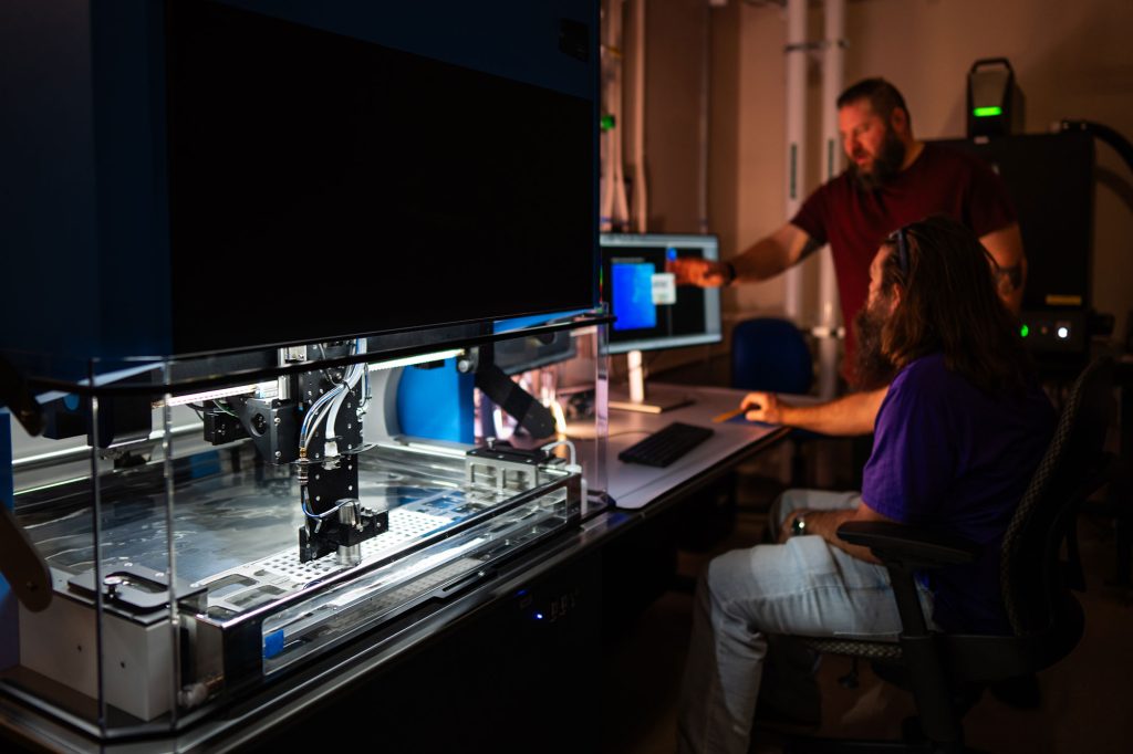 <strong>WITH AI’S HELP </strong>— Sandia staff work to set up a new ultrasonic tool that will use artificial intelligence to inspect ceramics components used in nuclear deterrence applications, replacing a time-consuming manual method. (Photo by Craig Fritz)