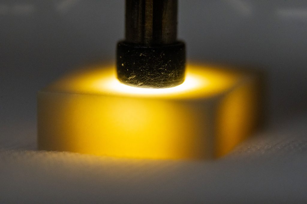 <strong>EARLY INSPECTIONS</strong> — Technicians at Sandia use a small wand of light and a microscope to manually inspect ceramic components for tiny defects. The process is time-consuming, challenging on the eyes and requires extensive training. With the introduction of artificial intelligence and new equipment, inspections will take place earlier in the production process. (Photo by Craig Fritz)