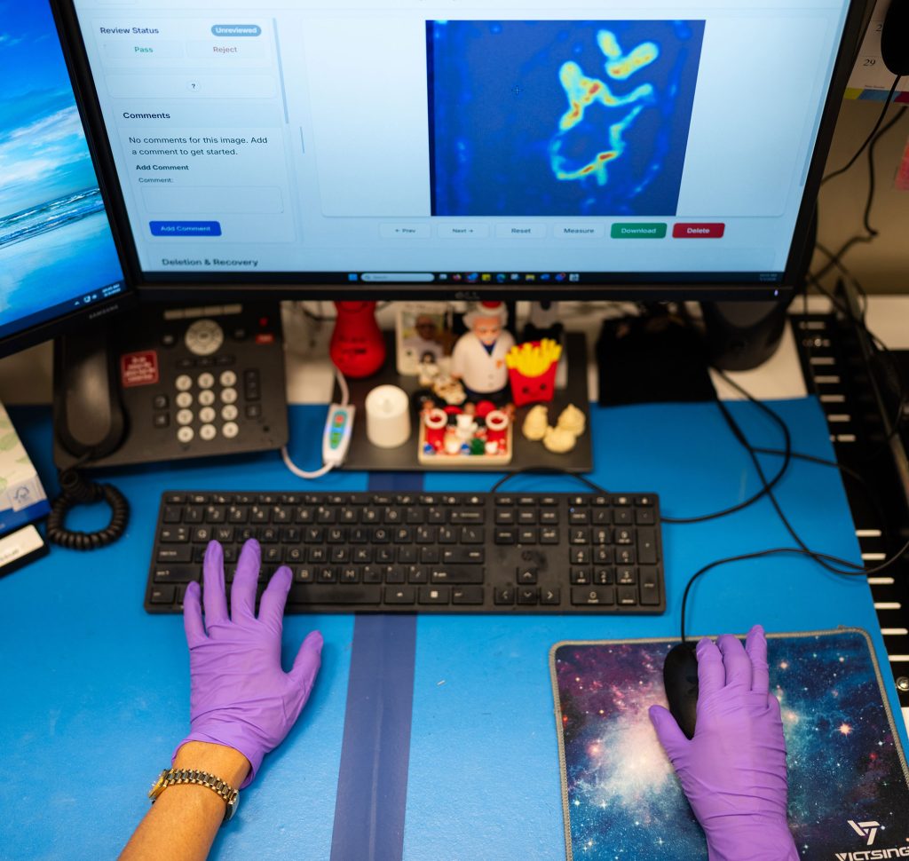 <strong>SPEEDIER INSPECTIONS </strong>— A technician at Sandia reviews a scanned image of a ceramic billet from her desktop. The Labs is transitioning from using a manual inspection to one that uses artificial intelligence to flag defects. Technicians will still review the results for quality control. (Photo by Craig Fritz)