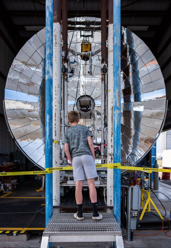 <strong>FUTURE REFLECTED</strong> — Jack Grange, 12, takes a closer look at the solar furnace at the National Solar Thermal Test Facility on a Kids Day tour with his dad, Spencer.