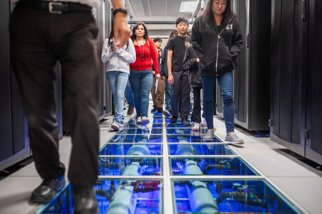<strong>COOL COMPUTING</strong> — Families tour the Corporate Computing Facility, where cooling system for super computers runs through the floor, during Kids Day on April 29. The event drew 2,409 students for a full day of science demonstrations and behind-the-scenes tours.