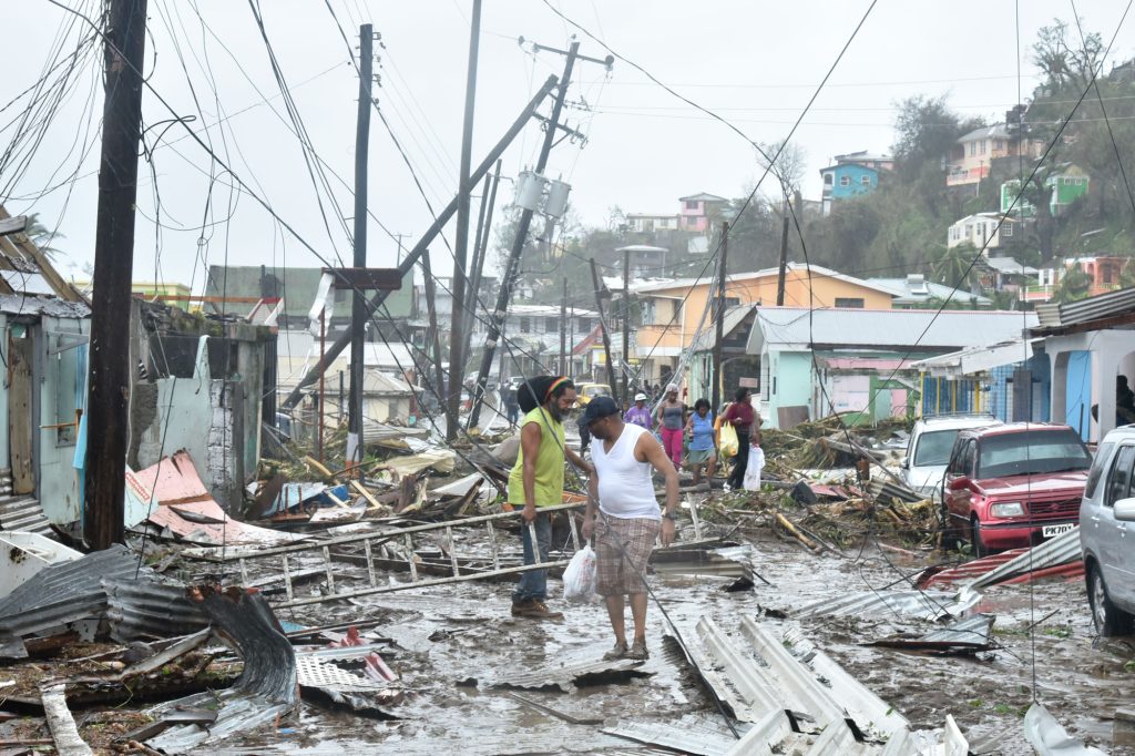 <strong>PICKING UP THE PIECES</strong> — Puerto Rican residents recover their belongings amid down power lines in the aftermath of Hurricane Maria in September 2017. (Photo by Roosevelt Skerrit)