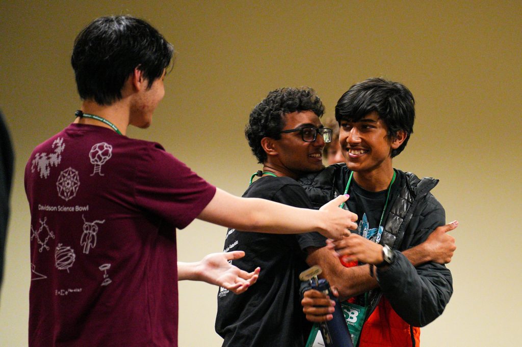 <strong>HEADED TO FINALS</strong> — From left, Mission San Jose High School team member Julian Kuang congratulates teammates Roshan Annamalai and Theenash Sengupta for advancing to the finals at the DOE National Science Bowl on May 3. The team competed at the Sandia-sponsored regional competition in Livermore in January and took home the national title on May 4. (Photo by Joshua Lawton, DOE Office of Science)