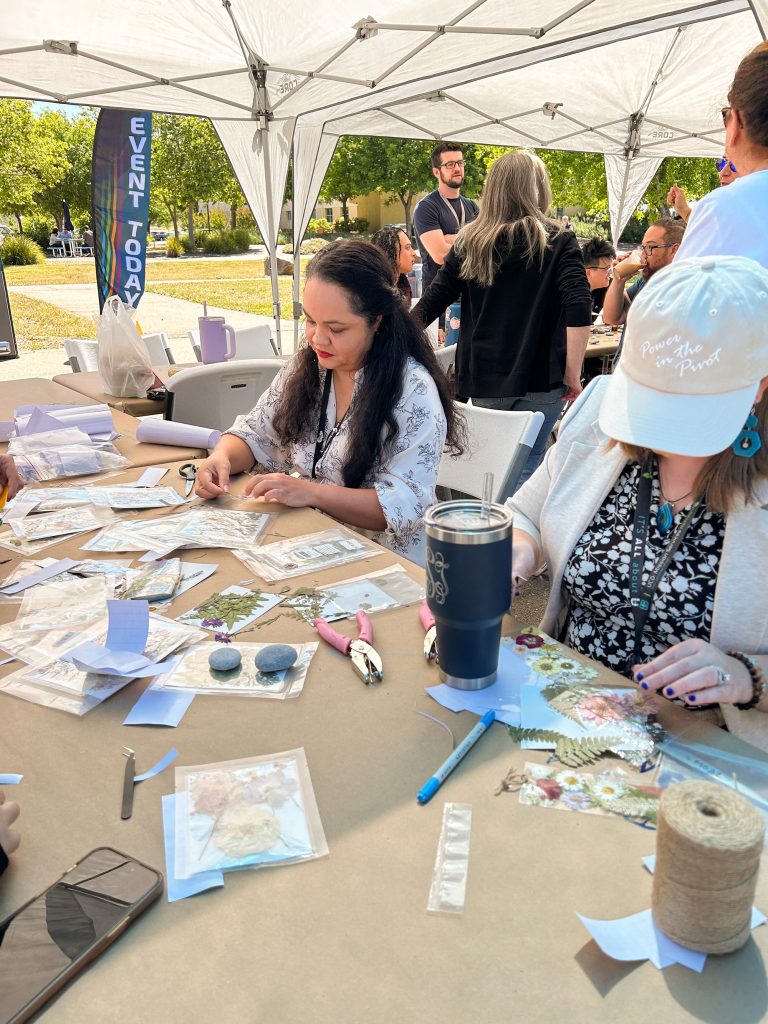 <strong>FLOWER POWER</strong> — Manager Karla Reyes, left, makes a dried flower bookmark with members of the Sandia California Division Council. (Photo by Lea Blevins)
