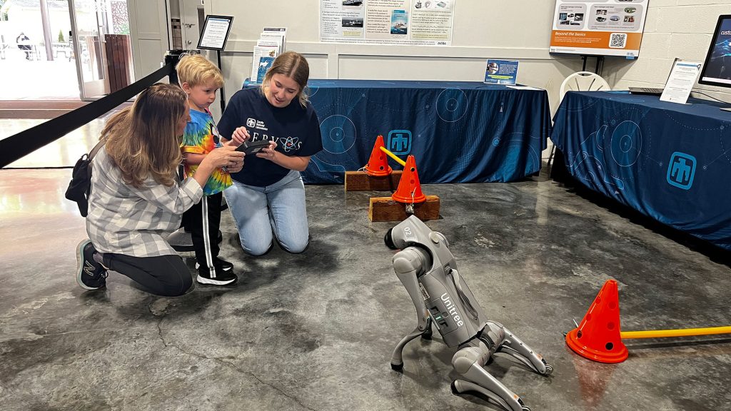 <strong>GOOD DOG</strong> — Amelia Harrison, right, shows Chip Watson, the robot dog, to fair attendees. (Photo by Michelle Walker-Wade)