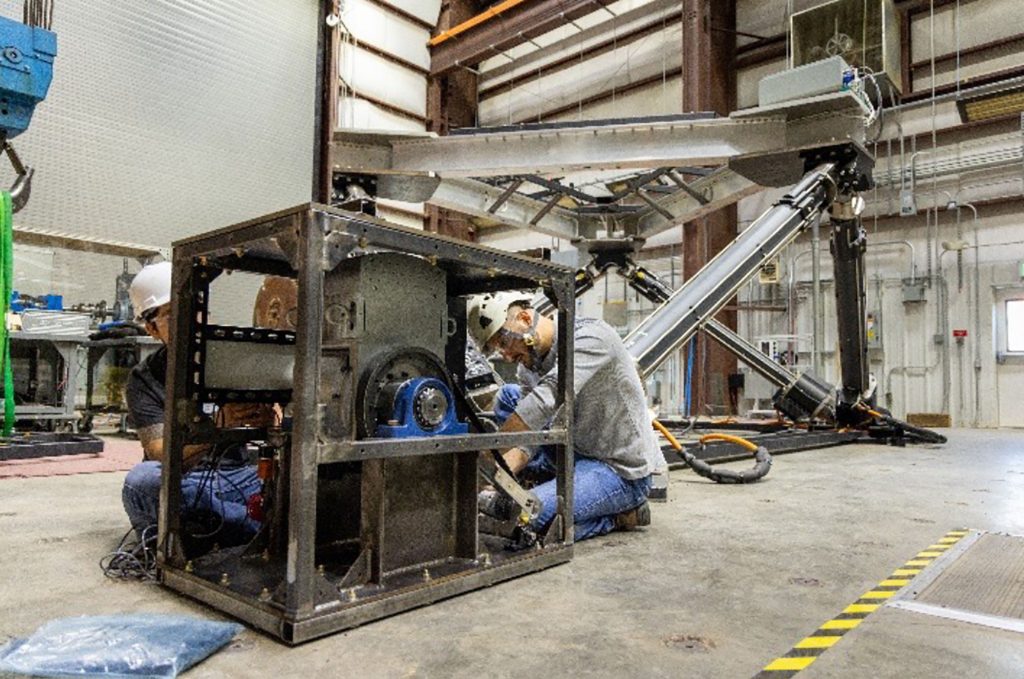 <strong>FINAL TOUCH</strong>&nbsp;—&nbsp;From left, Damian Gallegos-Patterson and Jantzen Lee adjust the Pioneer Wave Energy Converter before it is sealed in a box for deployment in the Atlantic Ocean. (Photo by Taylor Mankle and Joshua Bauer, National Laboratory of the Rockies)