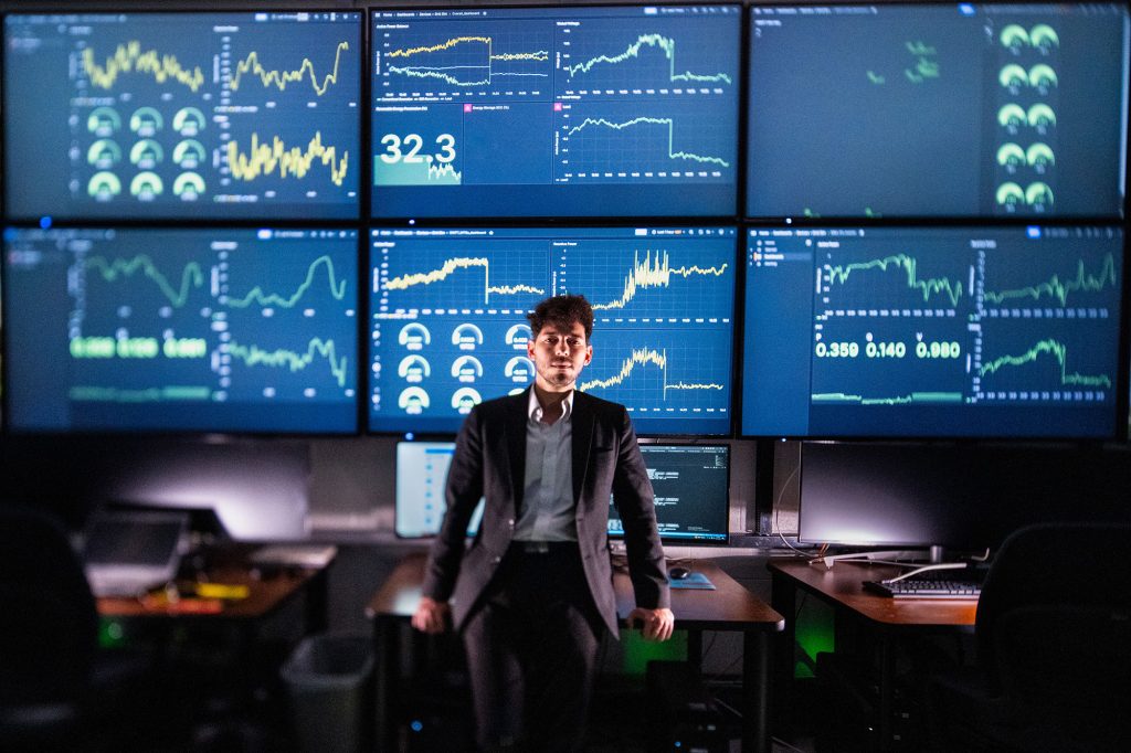 <strong>DASHBOARD VIEW</strong> — In Sandia’s Distributed Energy Technologies Laboratory, engineer Rachid Darbali-Zamora reviews the DERMS control dashboard used to coordinate grid-connected devices such as inverters, batteries and solar resources. The AI-enabled controls are being tested to improve voltage regulation and power quality for sensitive loads. (Photo by Craig Fritz)