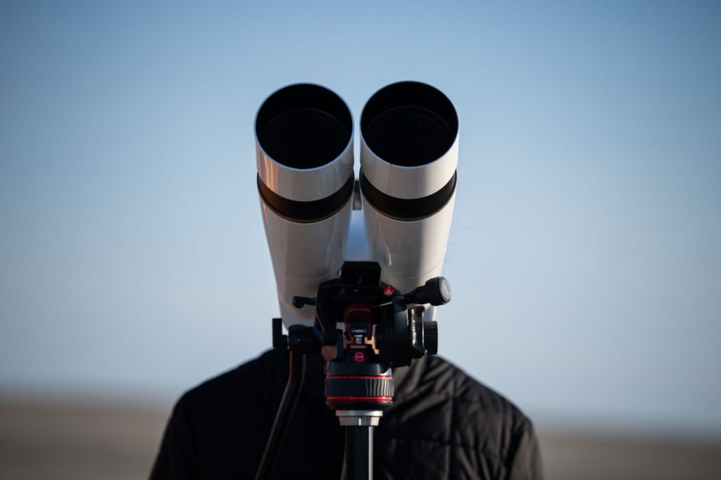 <strong>OBSERVATION</strong> — NNSA Genesis Mission lead Charles Ball observes the drop test through binoculars. (Photo by Craig Fritz)