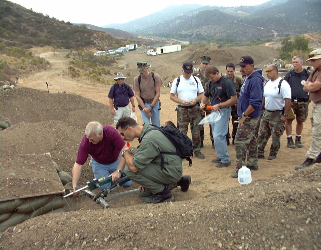 <strong>FORCE MULTIPLIER</strong> — Bomb-disablement expert Chris Cherry demonstrates use of the Percussion-Actuated Non-electric Disrupter to bomb technicians who participated in the Operation America workshop near San Diego in 2002. (Photo from the Lab News archives)