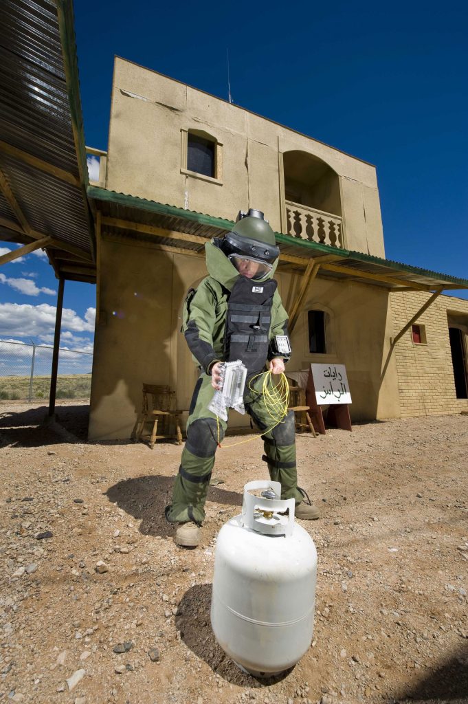 <strong>JUST SO </strong>— Airman 1st Class Patrick Connolly of Dayton, Ohio, demonstrates the placement of a water disruptor developed at Sandia near its target in a simulated village used to train soldiers heading overseas. (Photo by Randy Montoya)